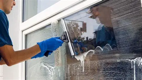 Technician washing a window with a squeegee
